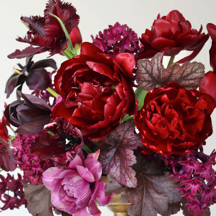 A dramatic arrangement of pink and burgundy spring flowers featuring tulips Black Parrot, Negrita Double, Midnight Magic and Continental, plus hyacinth Woodstock.