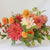 A lush summer flower arrangement featuring four dahlia varieties in warm autumn hues, including Break Out, Maarn, Belle of Barmera and Noordwijks Glorie.
