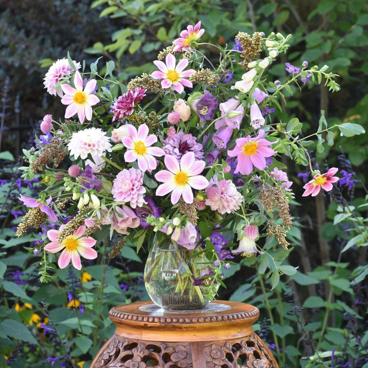A decorative vase with pale pink and purple blooms.